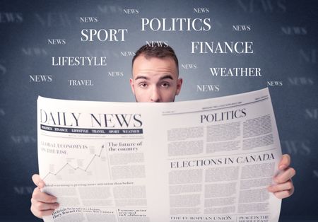 Young smart businessman reading daily newspaper