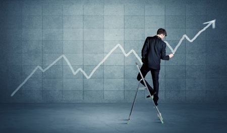 A man standing on a ladder and drawing a chart on blue wall background with exponential progressing curve, line