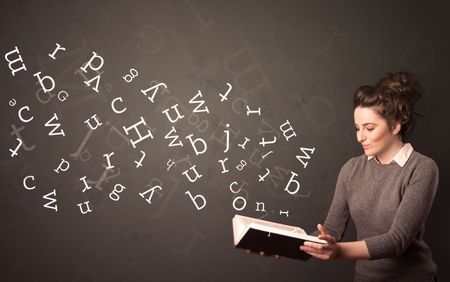 Casual young woman holding book with white alphabet flying out of it