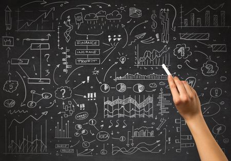 Female hand holding white chalk in front of a blackboard with a business plan drawn on it 