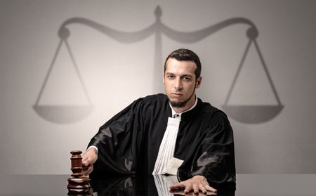 Young handsome judge in black gown making decision