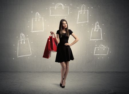A beautiful young girl in black standing with red shopping bags in front of brown background wall and drawing illustration concept