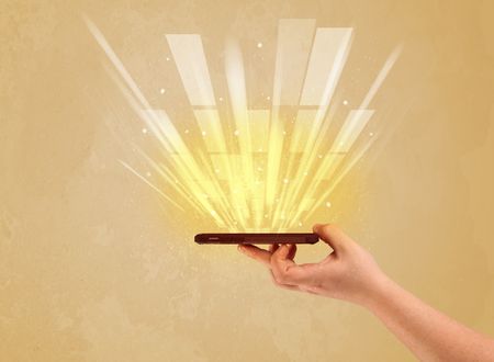 A caucasian hand holding a tablet phone with light beams and information escaping the device illustration concept
