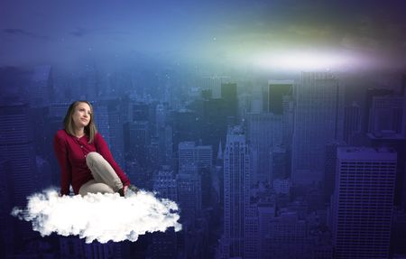 Caucasian woman sitting on a white fluffy cloud above the big city wondering