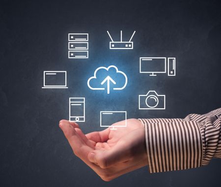 Cloud and computing related icons hovering over young hand 