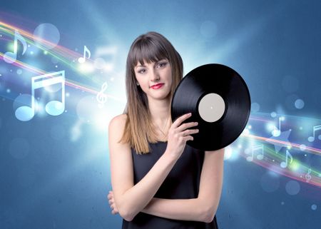 Young lady holding vinyl record on a blue background with musical notes behind her