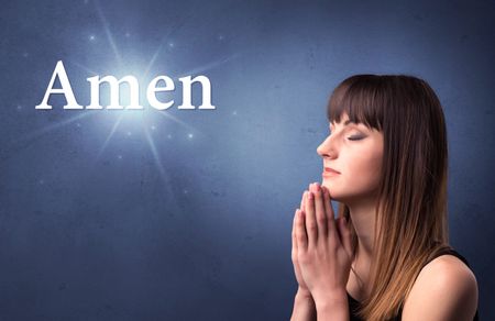Young woman praying on a blue background with the word Amen written above her