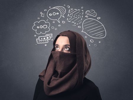 Young muslim woman wearing niqab with drawn speech bubbles above her head 