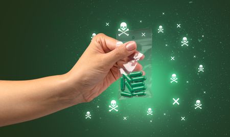 Female handing over pills with skull concept 