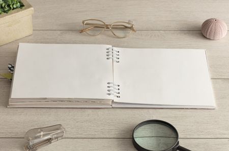 Empty notebook on wood floor with office tools nearby