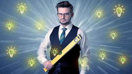 Better-looking businesman holding tool with idea bulbs concep