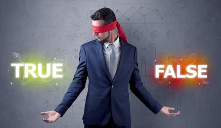 Businessman with red ribbon on his eye deciding true or false