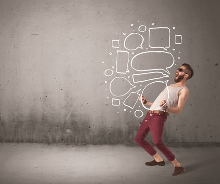 A comic hipster guy shouting in front of grey urban concrete wall with drawn empty text bubbles around his mouth concept