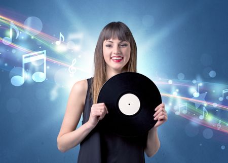 Young lady holding vinyl record on a blue background with musical notes behind her