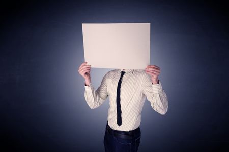 Young businessman hiding behind a blank piece of paper