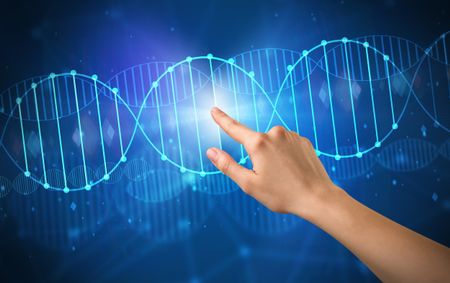 Female hand touching DNA molecule with blue background 