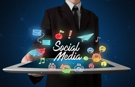 Businessman holding tablet with social media icons