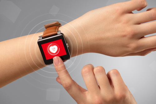 Naked female hand with smartwatch and with heart rate icon on the watch