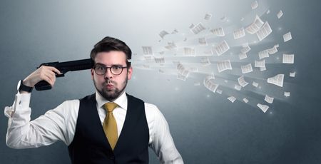 Handsome businessman shoots his head with gun and documents coming out from his head
