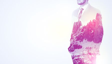  Young businessman in suit standing with sunny snowy mountain and trees graphic.