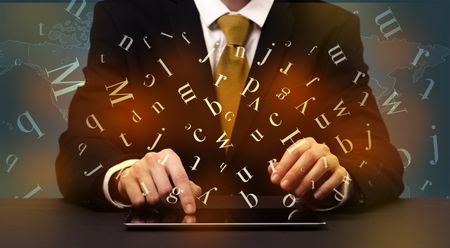Young man in suit and formal clothing typing with letters around