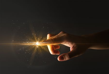 Female finger touching a beam of light