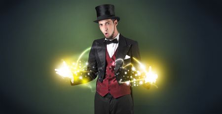 Magician holding his sparkling power between his two hand