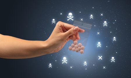 Female handing over pills with skull concept 