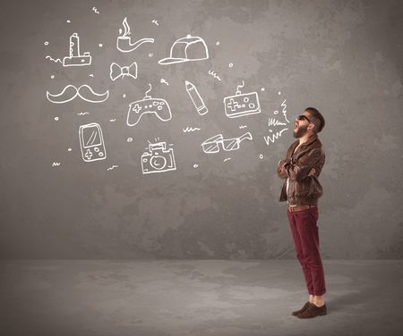A funny hipster person in casual urban clothing shouting drawn everyday items like camera, tie or pen on city wall concept
