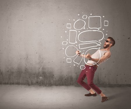 A comic hipster guy shouting in front of grey urban concrete wall with drawn empty text bubbles around his mouth concept