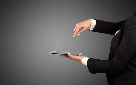 Female hand in suit holding tablet with no wallpaper