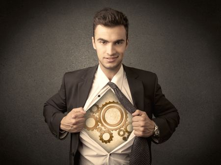 Businessman tearing shirt off and machine cog wheel shows on his chest concept on background