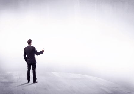 Young sales businessman in elegant suit standing with his back in empty white space background concept