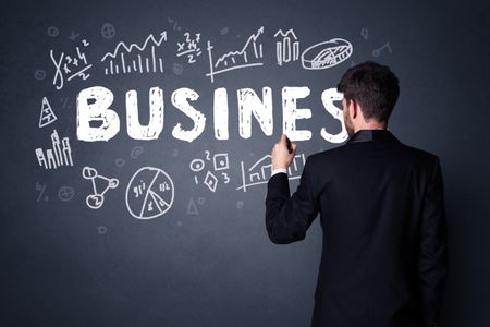 Young businessman in black suit standing in front of a detailed business plan