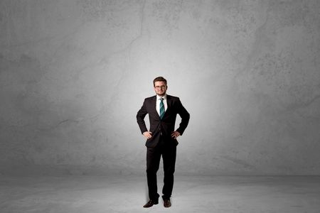 Alone handsome businessman standing in a dark empty room