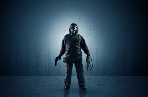 Bad agent in a dark room with arms on his hand and gas mask