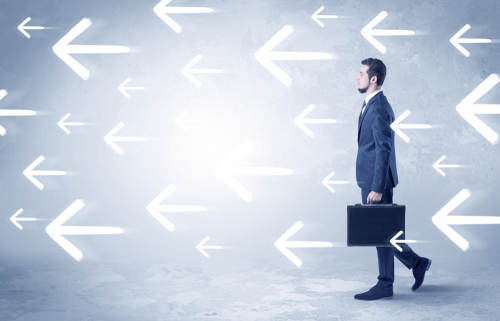 Businessman walking with arrows on the background and briefcase on his hand
