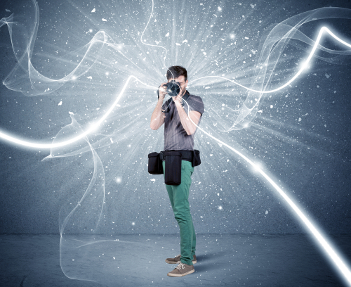 A young amateur photographer with professional photographic equipment taking picture in front of blue wall with dynamic white lines illustration concept