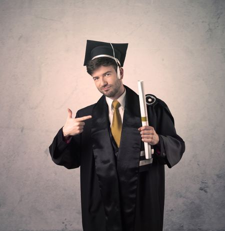 Portrait of a happy young graduate student on grungy background