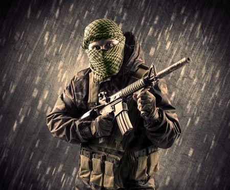 Close up of an armed terrorist man with mask on rainy background