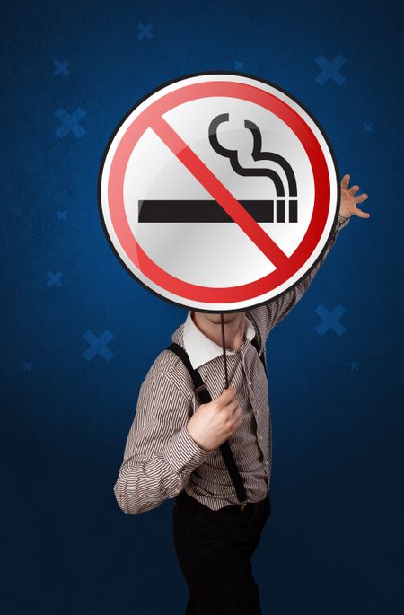 Casual businessman holding round sign with no smoking graphic