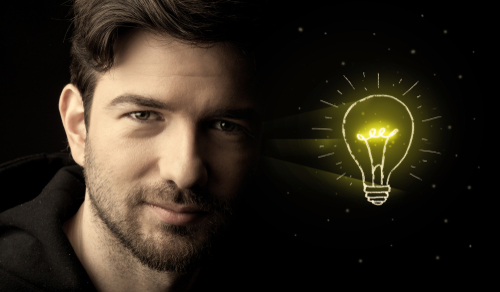 Close-up of young confident man with drawn light bulb