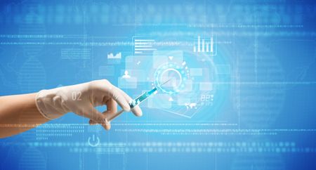 Female doctor hand holding syringe with blue background and charts