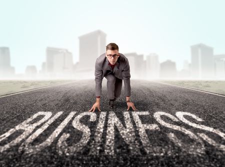 Young determined businessman kneeling before business text 