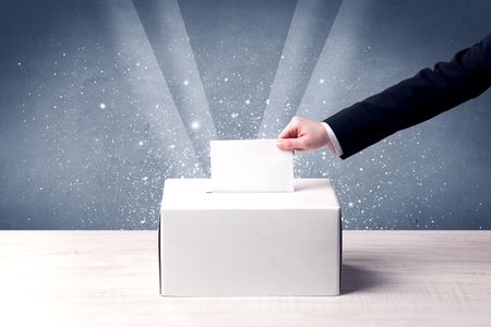 Ballot box with person casting vote on sparkling background