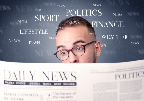 Young smart businessman reading daily newspaper