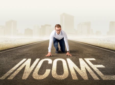 Young determined businessman kneeling before income sign