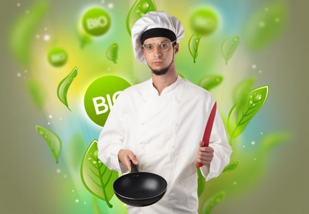 Green bio leaves concept and cook portrait with kitchen tools
