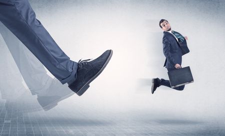 Businessman big foot kicking small, young businessman who is flying
