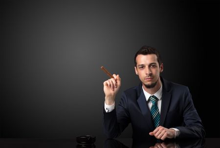 Businessman holding cigarette in his hand and wearing suit.